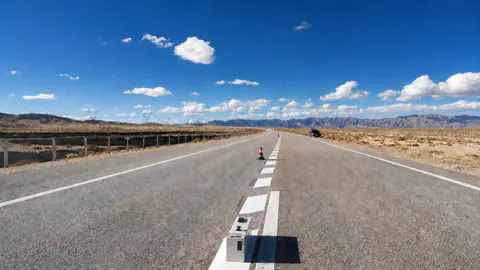 Long white edge line running down a desert highway toward the horizon