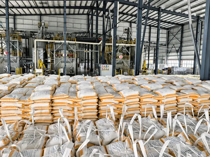 Thermoplastic production hall at the Hezhou base — three automated lines with palletized bags in the foreground