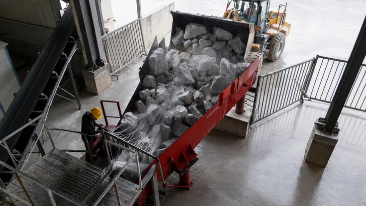 Loader tipping raw rock into the washing and primary crushing hopper