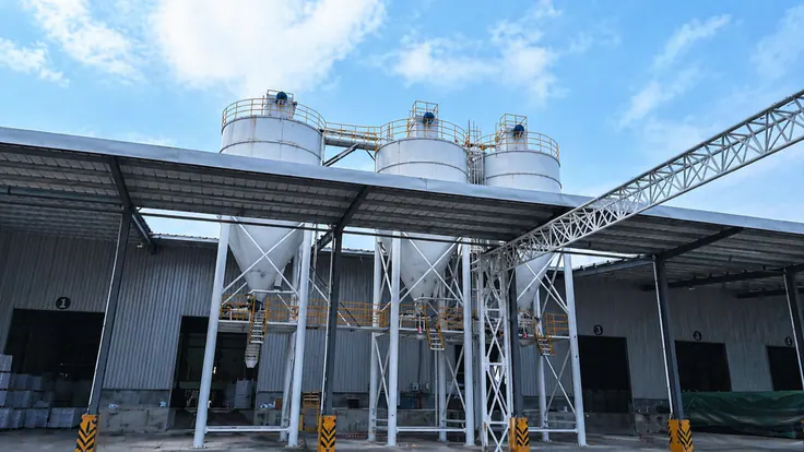 Storage silos and sealed pipelines moving raw material between plants