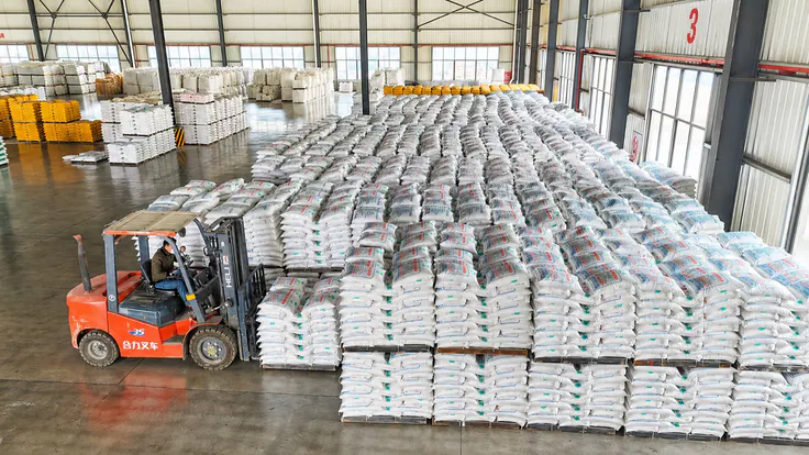 Forklift stacking palletized bags in the finished-goods warehouse