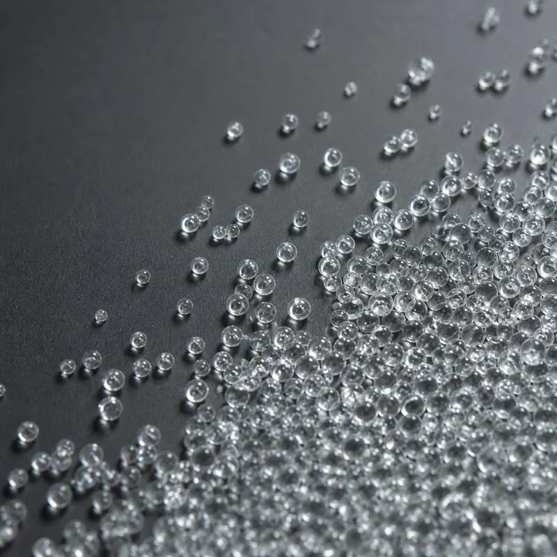 Macro shot of AASHTO M247 reflective glass beads on a dark studio background